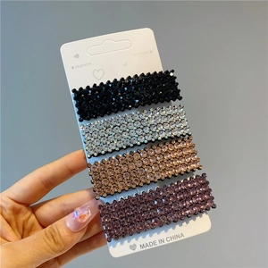 Detail of four luxury rhinestone geometric hair clips in black silver gold and purple colors