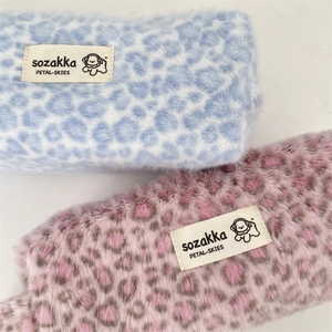 Detailed close-up of fluffy leopard print plush makeup bags with soft faux fur texture