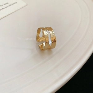 Detailansicht der goldfarbenen Hammerschlag-Textur auf dem doppelten Metallring