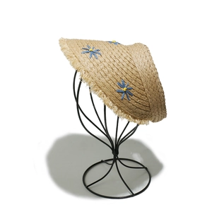 Detailed weave of sun visor straw hat featuring blue flower embroidery and fringe edge