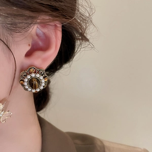Close-up of vintage flower earrings with brown tiger eye stone and white pearls