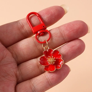 Macro detail of red floral keychain with golden pistil and matching metal lobster clasp