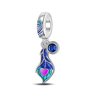Macro detail of enamel peacock feather charm with blue zircon and heart engraving
