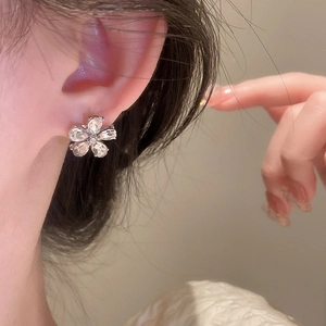 Close-up of sparkling floral stud earrings with clear crystals on a silver setting