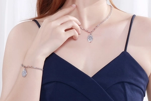 Silver double-layer necklace and bracelet set with oval relief pendants on female model