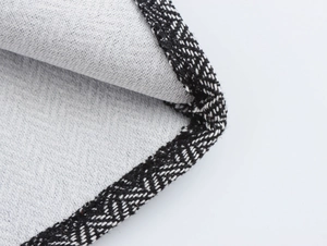 Detailed macro view of the contrast color lapel stitching on tweed blazer and skirt set