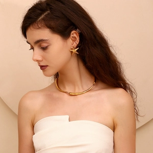 Golden starfish stud earrings and minimalist tube collar necklace set on a model