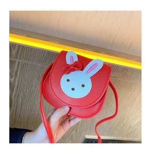 Detail of red cartoon bunny crossbody bag for kids with bow decoration and PU leather texture