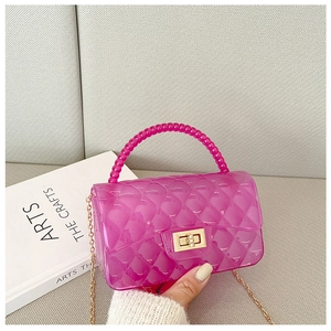 Pink translucent jelly bag featuring beaded handle and golden twist lock detail