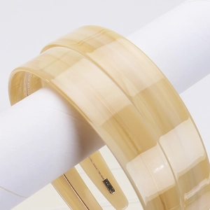 Detailed view of two 2.2cm wide vintage cream acetate headbands with a smooth glossy finish