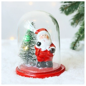 Detail of Christmas snow globe with LED pine tree and hand-painted Santa Claus figurine