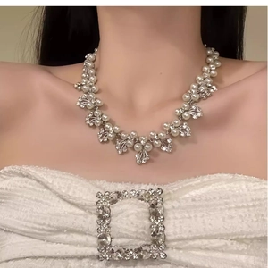 Detail of layered pearl and rhinestone necklace set on model with luxury vintage style