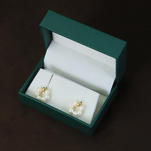 Elegant pearl hoop earrings in golden base with dark green jewelry gift box