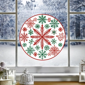Nahaufnahme eines runden Weihnachtsfensteraufklebers mit roten und grünen Schneeflocken