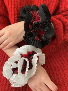 Detail of red checkered ruffled oversized scrunchies styled on a model wrist