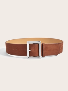Gros plan de la large ceinture en daim marron avec boucle carrée en métal argenté