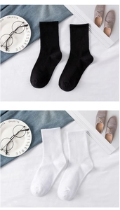 Flat lay of breathable white and black ribbed cotton mid-calf socks with lifestyle props