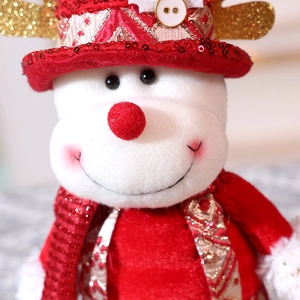 Nahaufnahme der Weihnachts-Schneemann-Plüschpuppe mit roten Pailletten und Goldstoff