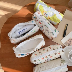 Detailed view of quilted cotton pouches featuring lemon, dog, and floral patterns