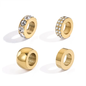 Détail de quatre perles en acier inoxydable doré avec strass et finitions polies brillantes