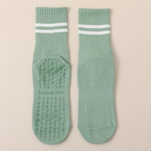 Detail of mint green yoga socks with white stripes and non-slip silicone grip bottom