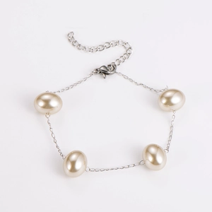 Detailed view of women's layered faux pearl bracelet with silver chain and lobster clasp