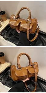 Detail view of brown vintage saddle bag with decorative flap pockets and smooth PU leather