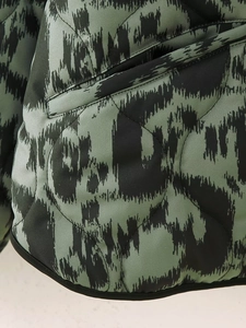 Detailed view of quilted cotton coat with retro green leopard print and side pocket