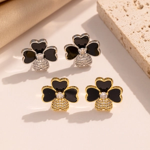 Macro detail of four-leaf clover stud earrings with black enamel and zircon inlay
