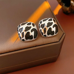 Détail de boucles d'oreilles carrées argentées avec émail imprimé léopard noir