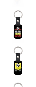 Close-up of three football leather keychains with motivational quotes and sports motifs