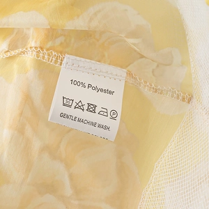 Detail of 100% polyester floral fabric with care label and washing instructions