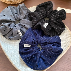 Trois chouchous en tissu rayé gris, noir et bleu marine avec broderie de nœuds