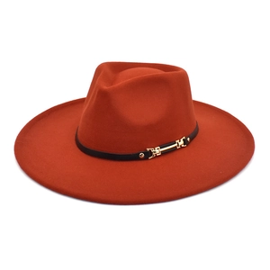 Detail of burnt orange wool fedora hat with black leather band and gold metal buckle