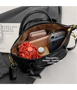 Detail shot of black leather tote bag capacity with umbrella, phone and wallet inside