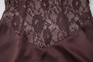 Close-up of wine red lace and shiny satin patchwork on a deep V-neck evening dress