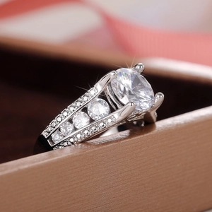 Anello classico con zircone rotondo a quattro griffe e pavé di diamanti laterali