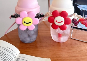 Close-up of cute plastic water bottles with 3D sunflower charms and woven straps