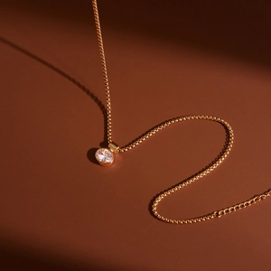 Dettaglio della collana in acciaio inossidabile dorato con ciondolo in zircone tondo