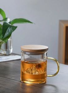 Detailed view of a glass tea mug with a mountain-shaped filter and wooden lid
