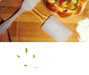 Silicone baking set with translucent oil brush and spatula on wooden background