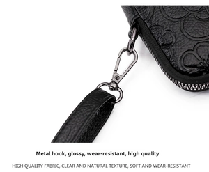 Détails du cuir gaufré floral et du fermoir mousqueton en métal poli sur le sac noir