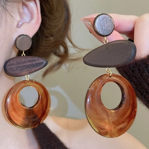 Detail of vintage geometric earrings with wood and amber resin drop pendants