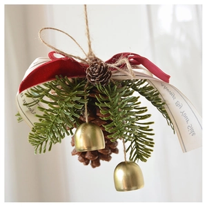 Close-up of Christmas pine cone pendant with green needles, red velvet bow and golden bells