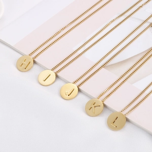 Detail of parallel gold round pendants with engraved alphabet letters H to L