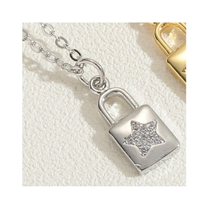 Macro shot of silver padlock pendant with zircon star inlay and fine link chain