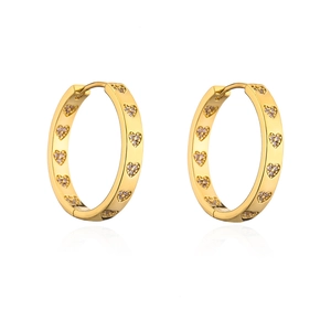 Close-up of gold plated hoop earrings with heart-shaped zircon stones and polished finish