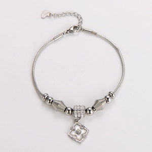 Detailed view of silver stainless steel snake chain bracelet with flower and heart charms