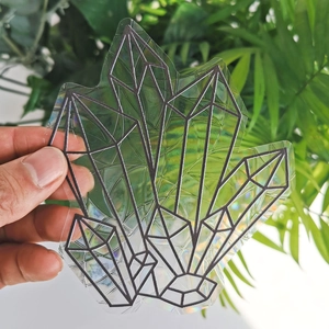 Macro shot of a geometric crystal suncatcher sticker with holographic prism effect