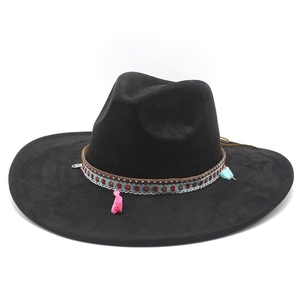 Close-up of black felt fedora featuring ethnic ribbon with floral pattern and tassels